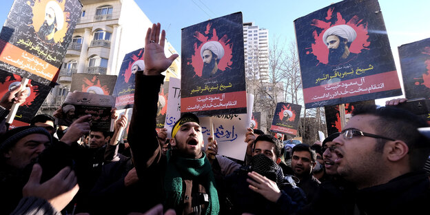 Iranische Männer protestieren mit Fotos des in Saudi-Arabien hingerichteten Scheichs Nimr al-Nimr
