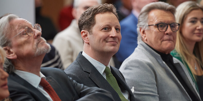 Drei Männer im Anzug sitzend in der Bundespressekonferenz