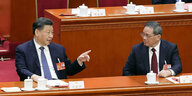Xi Jinping und Li Qiang sitzen nebeneinander im Volkskongress und unterhalten sich