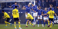 Dortmunder Spielöer ducken sich, die Schalker Freistoßmauer springt in die Höhe, Dortmuinds Raphael Guerreiro scheißt