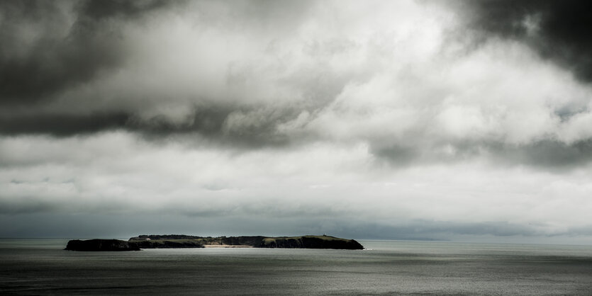 Eine Insel mitten im Meer an einem bewölkten Horizont