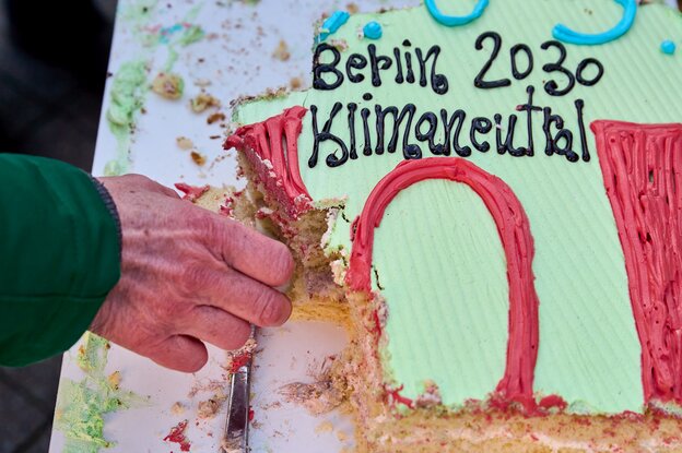 Hand greift nach Kuchen mit Zuckerguss-Aufschrift 