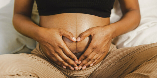 Hände auf dem Bauch einer Schwangeren