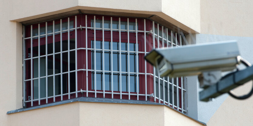 Ein Fenster mit Gittern und einer Kamera davor