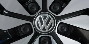 Das Bild zeigt ein VW-Logo in Nah an einem E-Auto.