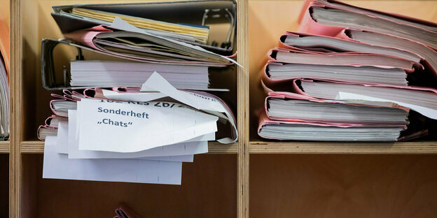 Two thick stacks of court files lie on a shelf