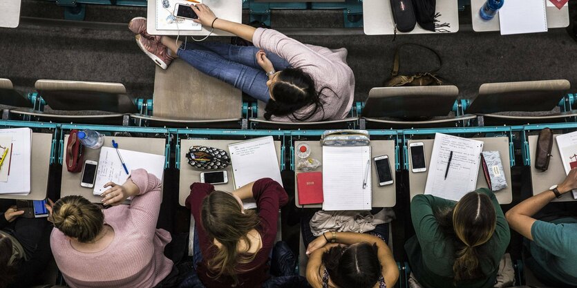 Übersicht von Studierenden, die in einem Hörsaal in den Bänken sitzen