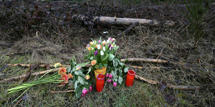 Blumen und Kerzen stehen in einer Waldlandschaft