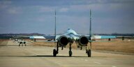 Ein Kampfjet des Typs Suchoi Su-27 steht in einer Reihe mit anderen Flugzeugen diesen Typs auf einer Startbahn
