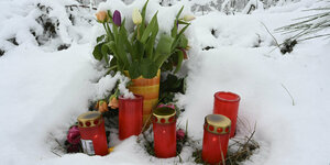Blumen und Kerzen im Schnee