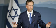 Israels Präsident Jizchak Herzog am Rednerpult vor der isrealischen Flagge.