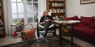 Irene Stoehr auf einem Sessel sitzend vor einem Buchregal