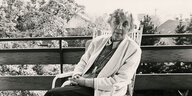 Eine alte Frau, es ist Ilse Losa, sitzt auf einem Balkon in der Kleinstadt Melle und schaut freundlich in die Kamera