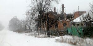 teilweise zerstörte Häuser in Winterlandschaft
