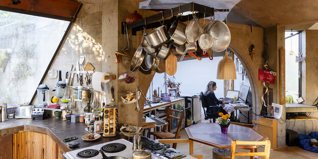 Pans and pots hang all over the place in an office kitchen