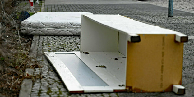 Eine Matratze und ein Schrank liegen auf der Strasse