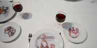 Gedeckter Tisch mit Tellern und Rotwein