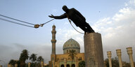 Eine Statue von Saddam Hussein fällt