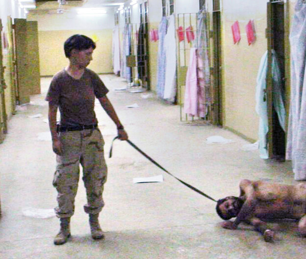 Eine Soldatin hat einen nackten Gefangenen an der Leine
