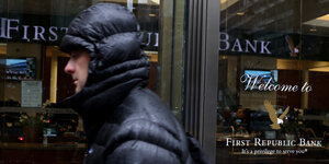 Ein Mann mit Kapuzenjacke läuft an einer Filiale der First Republic Bank vorbei