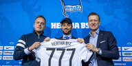 Hertha-Präsident Kay Bernstein, Josh Wander von 777 Partners und Hertha-Geschäftsführer Thomas E. Herrich halten ein Hertha-Trikot