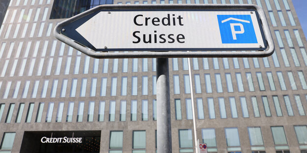 Ein Hinweisschild für das Parkhaus von Credit Suisse vor der grauen Fassade eines Bürohochhauses des Finanzunternehmens