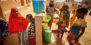 Kinder stehen an einer Wasserstelle in Niger