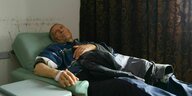 Krebspatient Ibrahim al-Omar liegt auf einem Bett mit einer Kanüle im Arm
