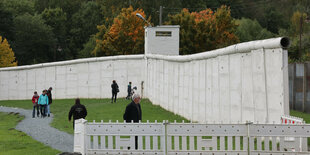 Besucher stehen vor einem Stück Grenzmauer der ehemaligen Staatsgerenze der DDR auf dem Gelände des Grenzmuseums am Rande des Deutschlandfest der CSU zum Tag der Deutschen Einheit.