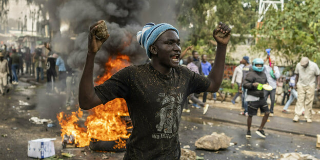 Ein Demonstrant wirft Steine Richtung Polizei im Slumviertel Kibera von Nairobi