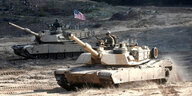 Zwei Abrams A1A1 fahren über ein Übungsfeld
