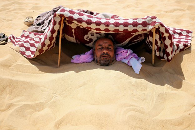 Ein Mann im Sand eingegraben
