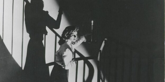 Eine Frau mit einem Leuchter auf einer Treppe