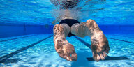 Ein Mensch schwimmt unter Wasser in einem Schwimmbad