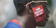Ein ugandischer Mann trägt einen Aufkleber mit der Aufschrift "Some Ugandans Are Gay. Get Over It"