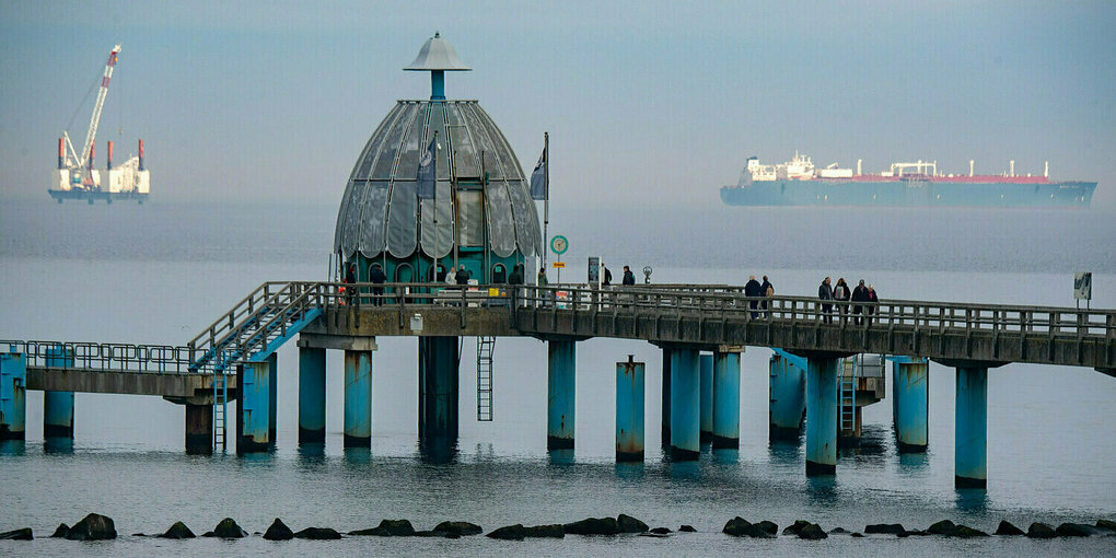 Die Seebrücke von Sellin auf, im Hintergrund sind eine Arbeitsplattform und ein LNG-Tanker zu sehen