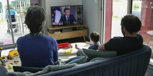 Eine Familie schaut Macrons Interview zu Mittagszeit