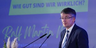 Polizeipräsident Ralf Martin Meyer an Mikrofonen vor einer violetten Wand auf der die Frage steht: "Wie gut sind wir wirklich?", darunter seine Unterschrift