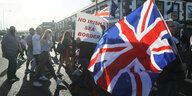 Demonstranten halten britische Fahnen hoch, auf einem Schild steht „No Irish Sea Border“