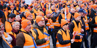 Eine Menschenmasse demonstriert in orangen Westen