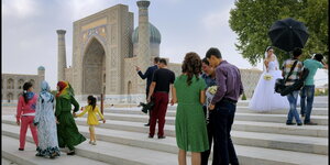 Menschen und eine Braut in Weiß am Registan Platz in Samarkand