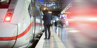 Ein Zugbegleiter auf dem Bahnsteig zwischen zwei ICEs