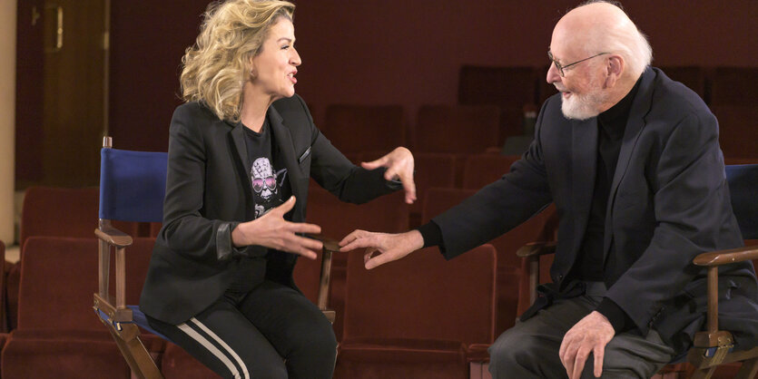 Anne-Sophie Mutter und John Williams sprechen miteinander am Rande eines Filmsets.