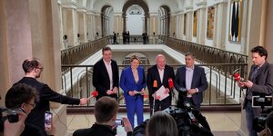 Die Spitzen von CDU und SPD stehen in einer Halle im Abgeordnetenhaus