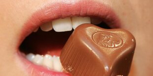 Praline vor roten Lippen