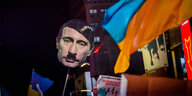Ein Schild mit dem Gesicht Putins mit Hitlerbart