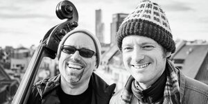 Der Bassist Joscha Oetz mit Kontrabass und der Rapper Kurt Tallert alias Retrogott über den Dächern von Köln.