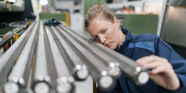 Eine Frau überprüft in einem High-Tech-Unternehmen ein Stahlmodell