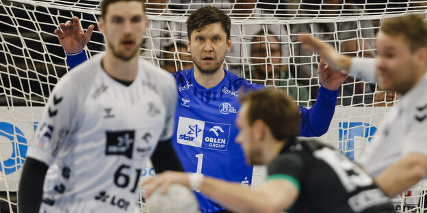 Ein Handballtorwart steht mit ausgestreckten Armen im Tor