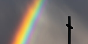 Regenbogen neben einem Kreuz